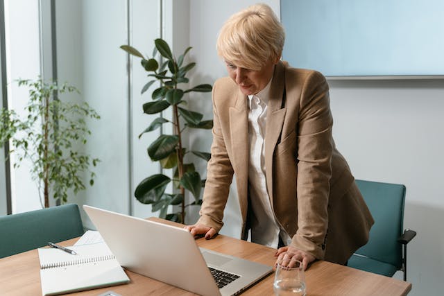 a%20property%20manager%20in%20a%20light%20brown%20jacket%20standing%20at%20their%20desk%20looking%20at%20a%20computer a%20property%20manager%20in%20a%20light%20brown%20jacket%20standing%20at%20their%20desk%20looking%20at%20a%20computer